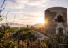 Xeraco abrirá al público la Torre de Guaita tras culminar la reconstrucción de sus plantas históricas Torre de piedra antigua al atardecer con montañas y vegetación al fondo