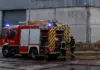 Un incendio en una nave del polígono dels Rajolars de Oliva moviliza a los bomberos de la comarca Bomberos desplegando mangueras junto a un camión para extinguir un incendio en una nave industrial
